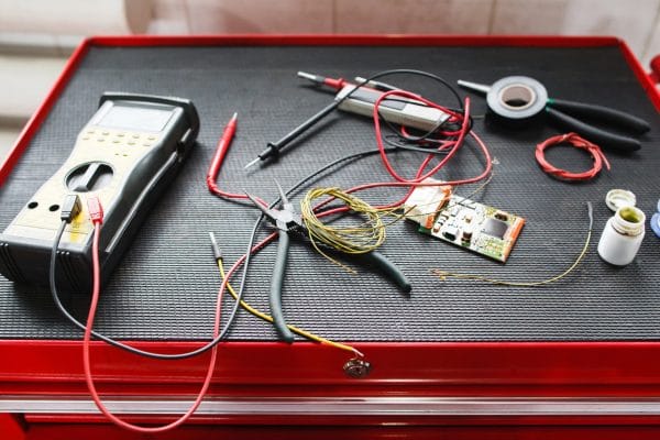 Stairlift Repairs Multimeter, wires, and circuit board on toolbox