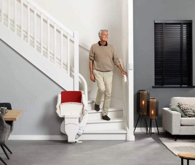Stairlift Older man using stairlift in modern home